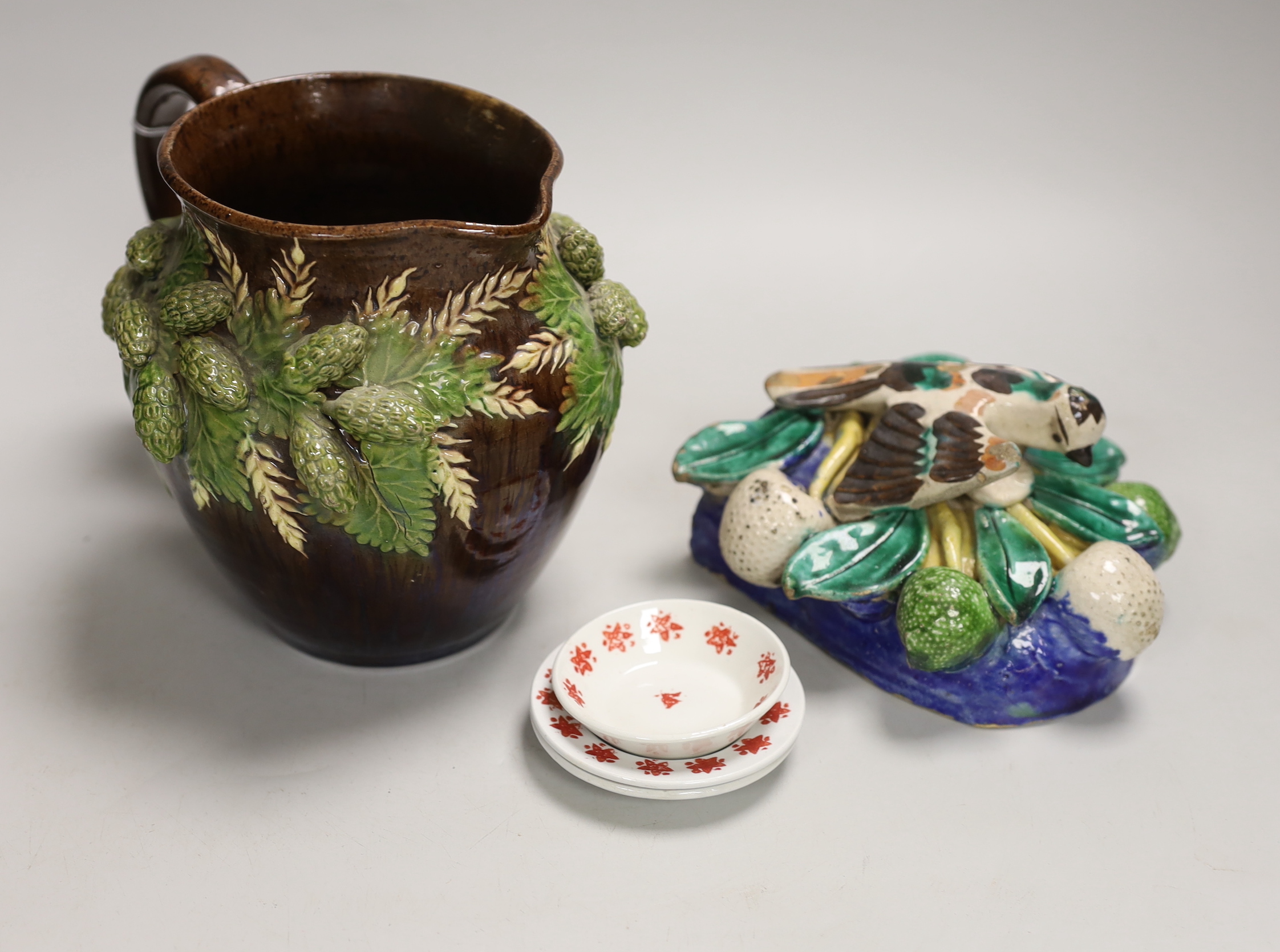 A Portuguese maiolica pottery wall pocket, a Rye pottery jug and three creamware dolls house plates